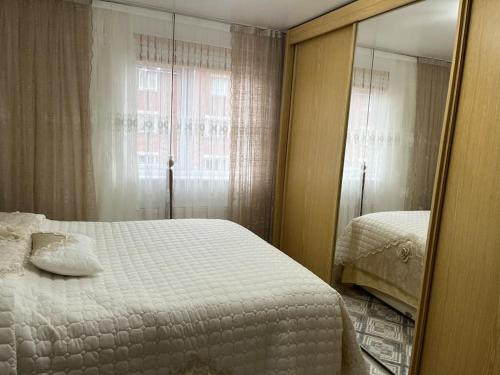 a bedroom with a white bed and a mirror at Entire flat In cardiff central in Cardiff