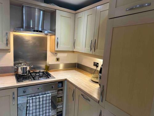 a kitchen with white cabinets and a stove top oven at Entire flat In cardiff central in Cardiff