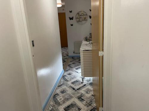 a hallway with a bathroom with a sink and a mirror at Entire flat In cardiff central in Cardiff