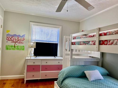 a bedroom with a bunk bed and a desk at Harmony House - cozy, private mountain home, with firepit and pool table, located 10 minutes from Tryon Equestrian Center, Lake Lure, Local Wineries, and wedding venues in Mill Spring