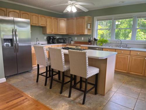 a kitchen with a refrigerator and a table and chairs at Harmony House - cozy, private mountain home, with firepit and pool table, located 10 minutes from Tryon Equestrian Center, Lake Lure, Local Wineries, and wedding venues in Mill Spring