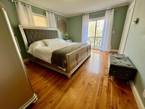 a bedroom with a large bed and a wooden floor at Harmony House - cozy, private mountain home, with firepit and pool table, located 10 minutes from Tryon Equestrian Center, Lake Lure, Local Wineries, and wedding venues in Mill Spring