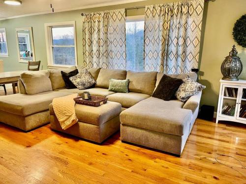 a living room with a couch and a table at Harmony House - cozy, private mountain home, with firepit and pool table, located 10 minutes from Tryon Equestrian Center, Lake Lure, Local Wineries, and wedding venues in Mill Spring