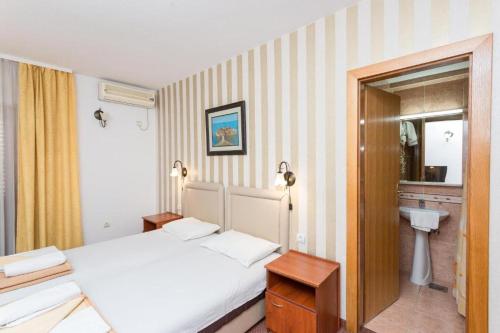 a bedroom with a white bed and a sink at Jerfihouse in Budva