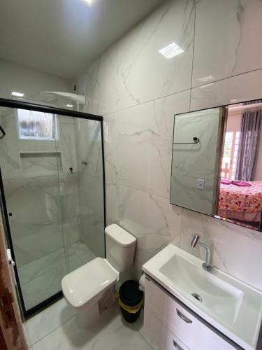a bathroom with a shower and a toilet and a sink at Pousada do Solar in São Lourenço