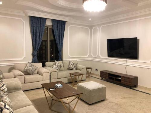 un soggiorno con divano e TV a schermo piatto di Distinctive chalet in Dur.Marina a Durat Alarous