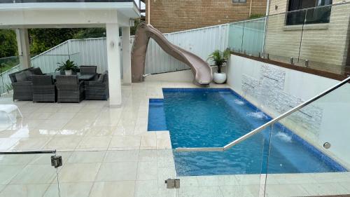 a swimming pool with a slide in a house at HEATed Pool, Lake & Beach, Luxury 5 B/R House in Lake Illawarra
