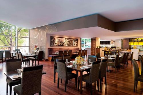 a restaurant with tables and chairs and a bar at Melbourne Marriott Hotel in Melbourne