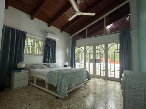 a bedroom with a bed and a large window at Villa Ramos - Private Beachfront with a View in Cabarete