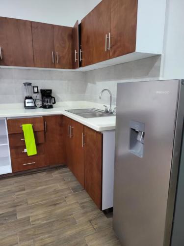 a kitchen with a stainless steel refrigerator and wooden cabinets at Suites Independencia Oaxaca in Oaxaca City