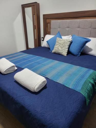 a large bed with two pillows on top of it at Suites Independencia Oaxaca in Oaxaca City
