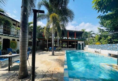 帕洛米諾的住宿－Hostal Luz de Luna，棕榈树游泳池和大楼