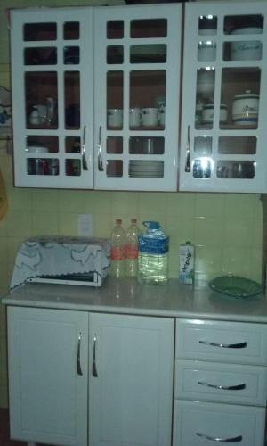 cocina con armarios blancos y encimera en Casa na Praia das Dunas em Cabo Frio, en Cabo Frío