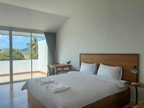 um quarto com uma cama grande e uma janela grande em idyllic apartment em Chaweng