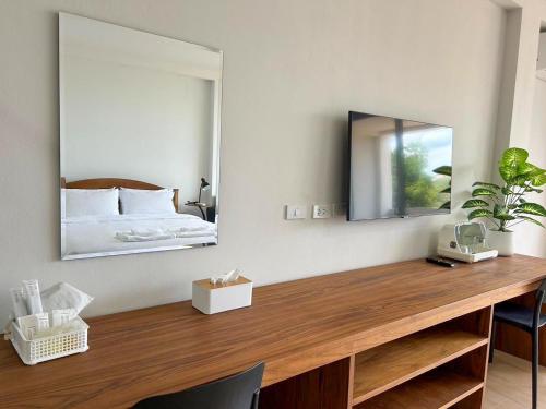 1 dormitorio con escritorio, espejo y cama en idyllic apartment, en Chaweng