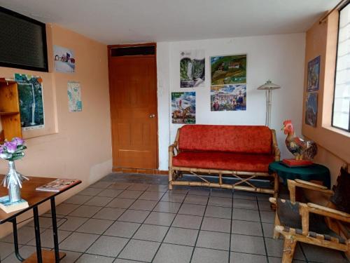 ein Wohnzimmer mit einem Sofa und einem Tisch in der Unterkunft Hostal Rincón Del Turista in Otavalo