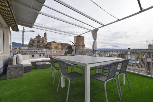 a table and chairs on a balcony with a view at Ático Panorama Catedral in Granada