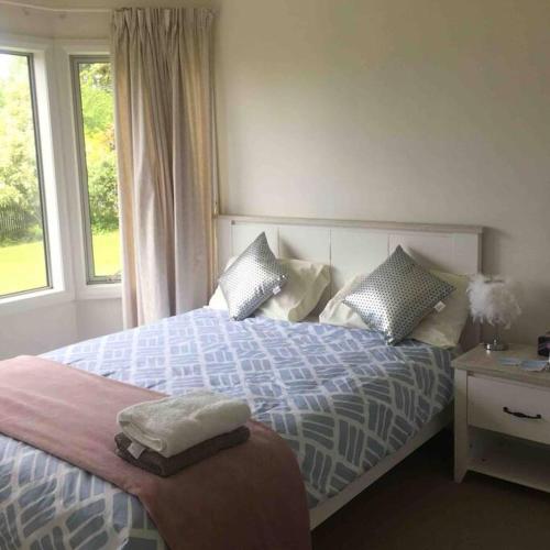 a bedroom with a bed with pillows and a window at memory in Auckland