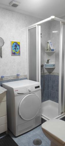 a bathroom with a white toilet and a shower at Habitación Centro Pontereas in Ponteareas