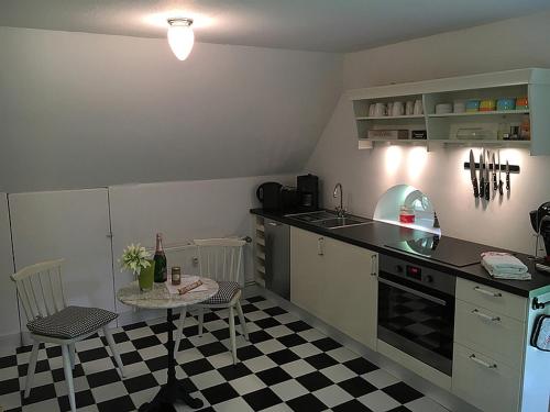 uma cozinha com piso em xadrez preto e branco em Katharinenhof App Marsch em Tönning