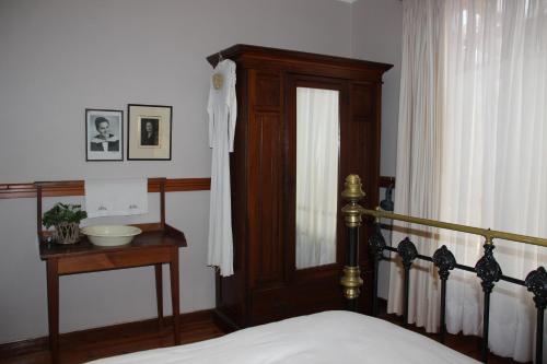 Schlafzimmer mit einem Bett mit einem Kopfteil aus Holz und einem Fenster in der Unterkunft Potteberg Guest Farm in Malgas