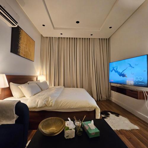 a hotel room with a bed and a flat screen tv at استديو. الياسمين للإيجار اليومي و دخول ذاتي. in Riyadh