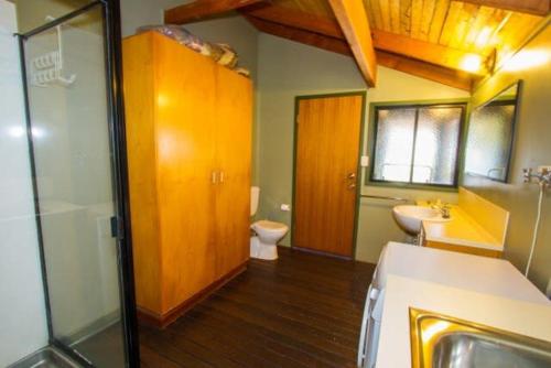 uma casa de banho com um lavatório, um WC e um chuveiro em Bimbimbi - Holiday hideaway by the bay of 1770 em Seventeen Seventy