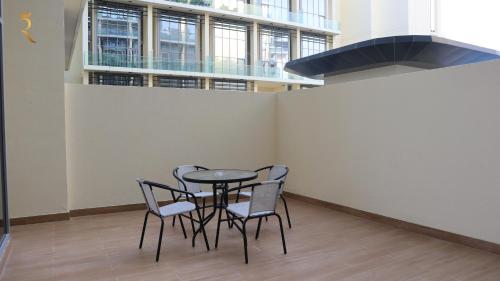 a table and chairs in an empty room with a window at Chalet Blissful - Serene 2BR Duplex Stay in Oasis, Near Masdar Park in Abu Dhabi