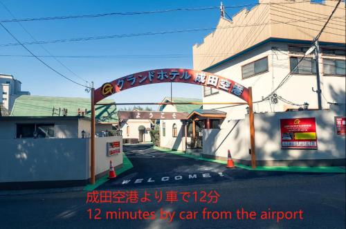 un arco sobre una calle con escritura en グランドホテル成田空港, en Akaike