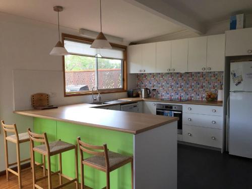 una cucina con un'isola verde al centro di South Coast Retreat a Manyana
