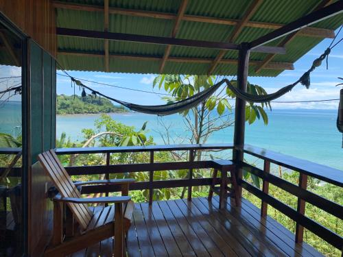 a porch with a hammock and a view of the ocean at VistaDrake Bungalow in Drake