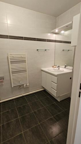 een badkamer met een wastafel en een spiegel bij Superb apartment next to Paris in Bois-Colombes