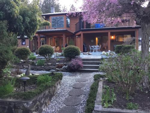 a house with a stone walkway in front of it at Nestledown B&B in Halfmoon Bay
