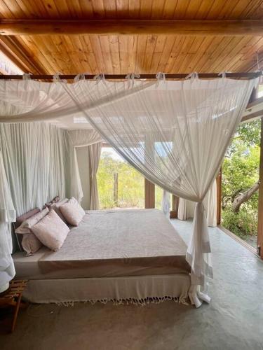 1 dormitorio con 1 cama con mosquitera en Casa Maiara (Eco friendly), en Moreré
