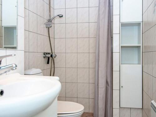 La salle de bains est pourvue de toilettes, d'un lavabo et d'une douche. dans l'établissement Holiday home Fanø VII, à Fanø