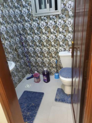a bathroom with a toilet and a mosaic wall at Biba Stay in Dakar
