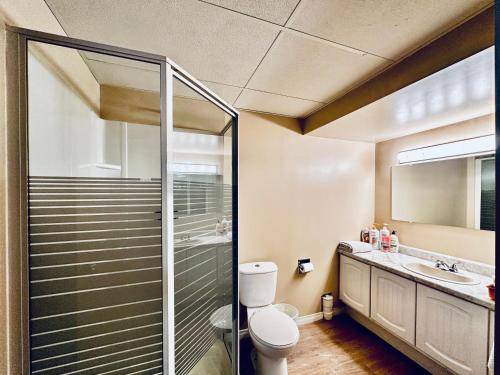 a bathroom with a toilet and a glass shower at Lake Simicoe town cottage near Innisfil Beach Park in Innisfil