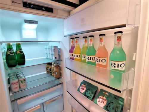 an open refrigerator filled with lots of bottles of soda at Interact China Fine Condo - Shenzhen Bay in Shenzhen