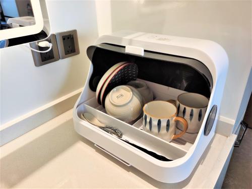 a toaster oven with dishes and cups in it at Interact China Fine Condo - Shenzhen Bay in Shenzhen