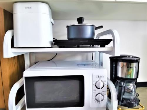 a microwave oven with a pot on top of it at Interact China Fine Condo - Shenzhen Bay in Shenzhen