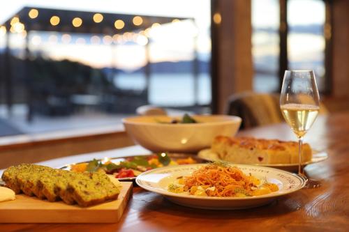 a table with a plate of food and a glass of wine at 4S resort eeyan in Ikisue