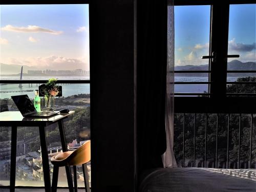 a room with a table with a laptop and a window at Interact China Fine Condo - Shenzhen Bay in Shenzhen