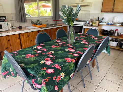 - une table avec un vase et des fleurs dans la cuisine dans l'établissement H&R House, à Tiva
