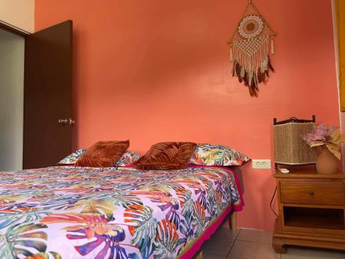 um quarto com uma cama com uma parede laranja em H&R House em Tiva