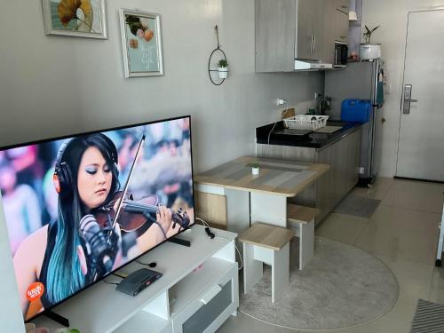 a television with a picture of a woman playing a violin at Brand new and fully furnished home away from home! in Manila