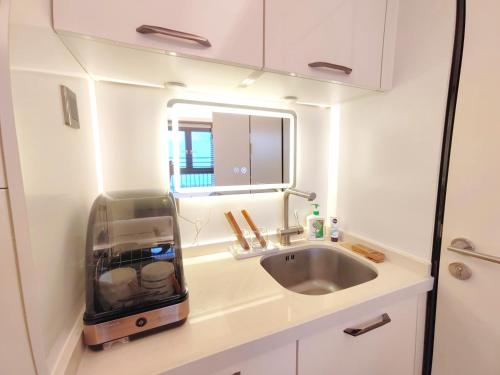 a small kitchen with a sink and a mirror at Interact China Fine Condo - Shenzhen Bay in Shenzhen