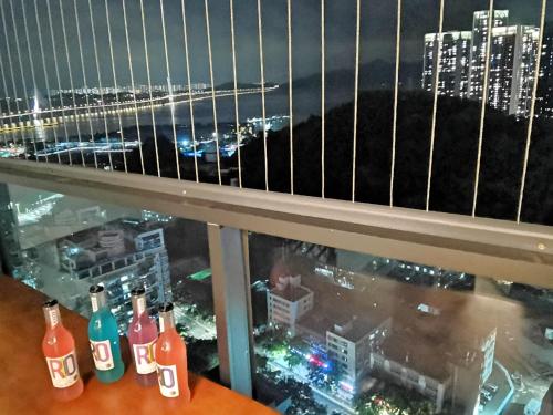 a view of a city skyline from a window with bottles on a table at Interact China Fine Condo - Shenzhen Bay in Shenzhen