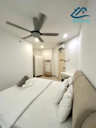 un grande letto bianco in una stanza con ventilatore a soffitto di Mansion One a George Town