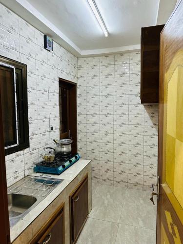 a kitchen with a sink and a stove top oven at As résidence meublée p.d in Ouagadougou