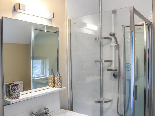 a bathroom with a shower with a glass door at Bron Madog in Mynfford